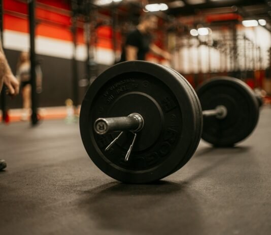 From Novice to Mastery: The Complete Journey of Muscle-Building Training a man squatting down next to a barbell in a gym