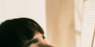 Silent Saboteur: How Sleep Deprivation Destroys Health and What You Can Do About It woman in white shirt looking down