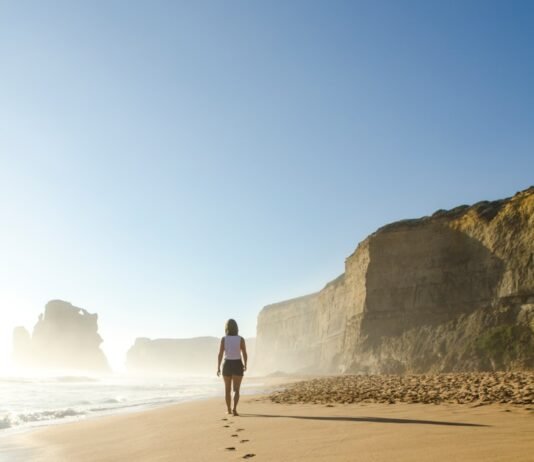 Breaking the Cycle: A Realistic Path to Beating Procrastination and Reclaiming Your Time woman walking on shore