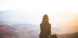 Strong at the Core: The Overlooked Art of Self-Care in Building Real Mental Resilience person sitting on top of gray rock overlooking mountain during daytime